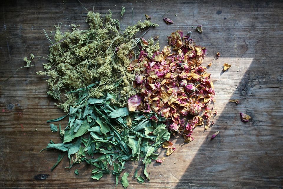 Dried herbs and rose petals on wood